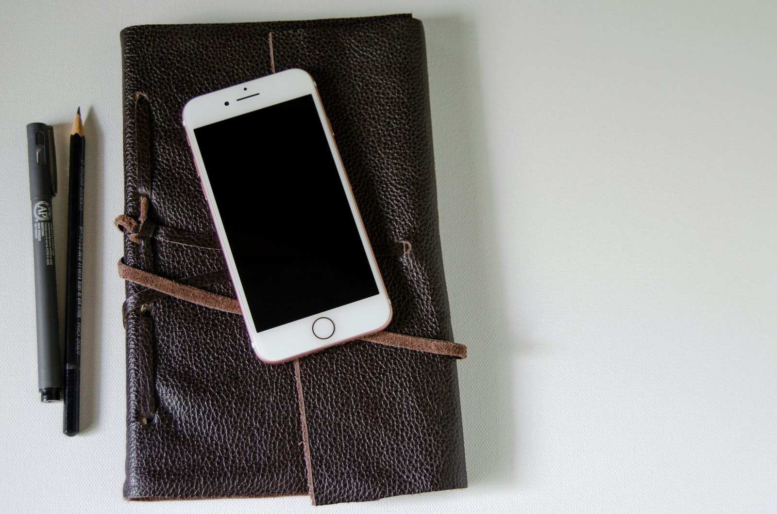 silver iphone 5s on black leather case
